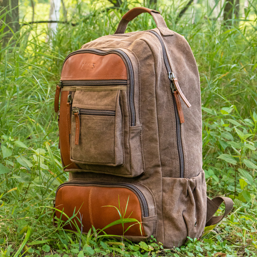 Retro Cantabrian Excursion Rucksack with leather in a grassy field.