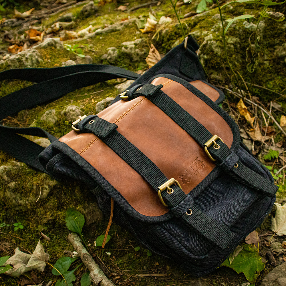 Retro Hipster Side-Bag laying on mossy rocks in the woods.