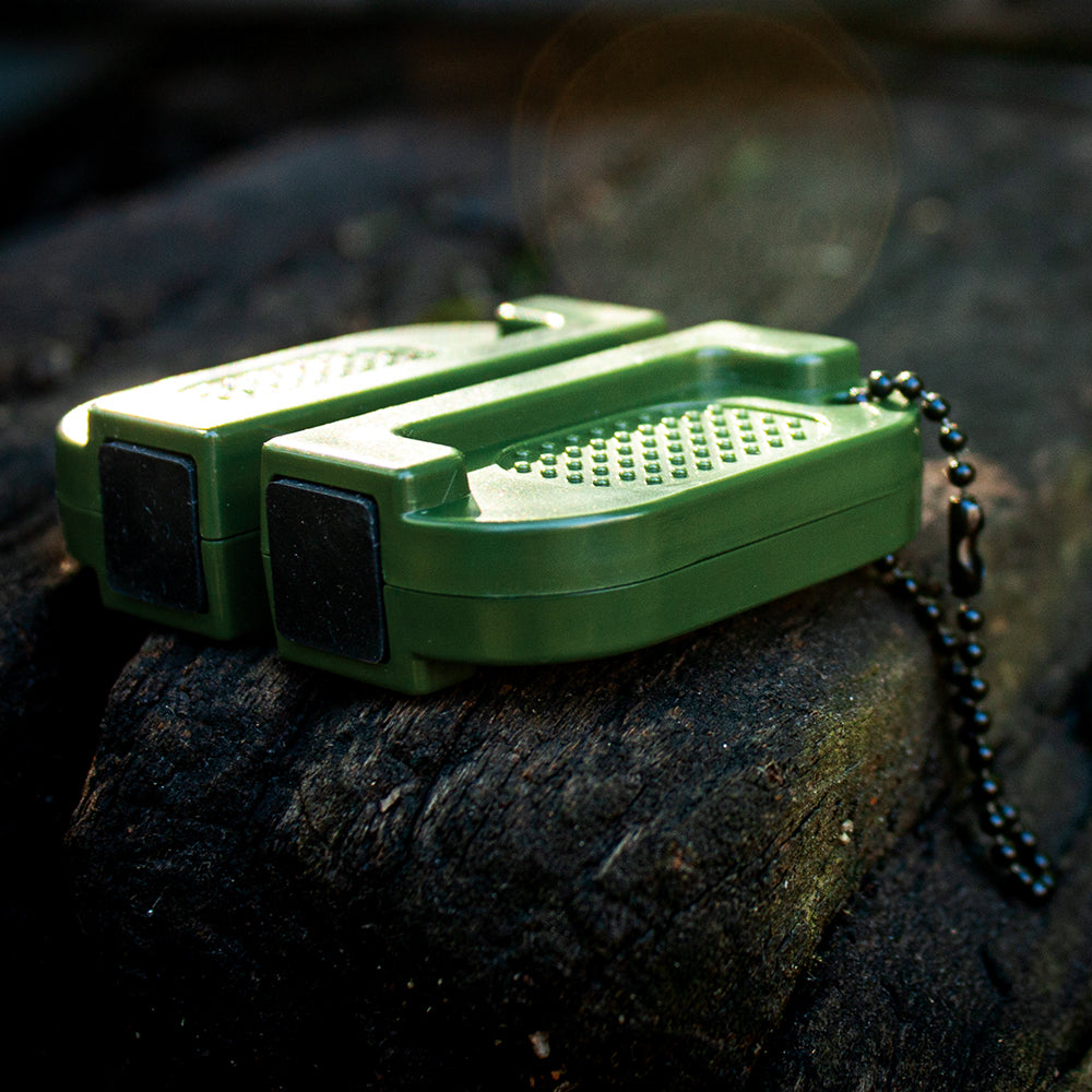 Compact Knife Sharpener on a dark mossy log.