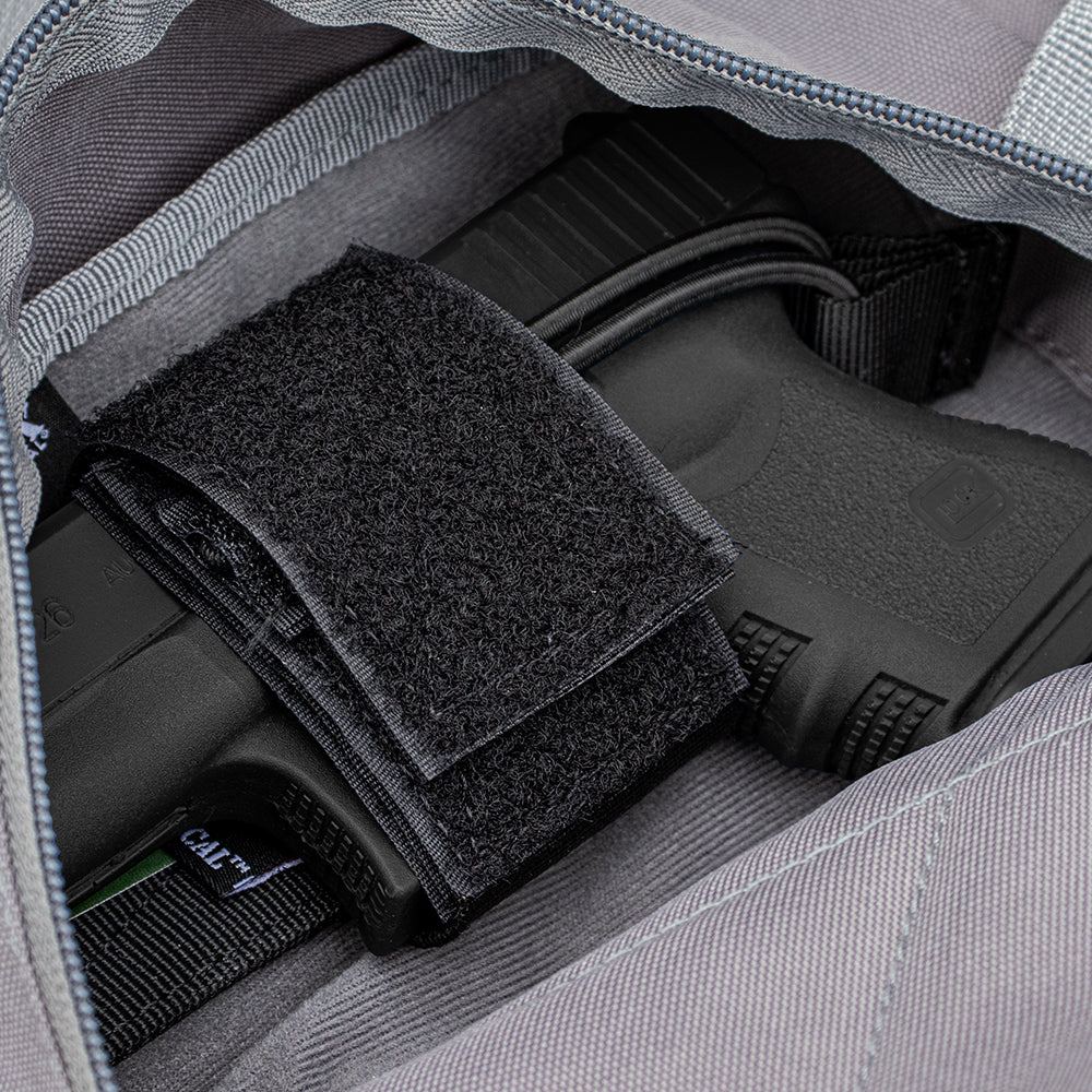 Closeup of a Universal Hook & Loop Holster with a pistol inside nestled into a hook & loop compatable compartment.