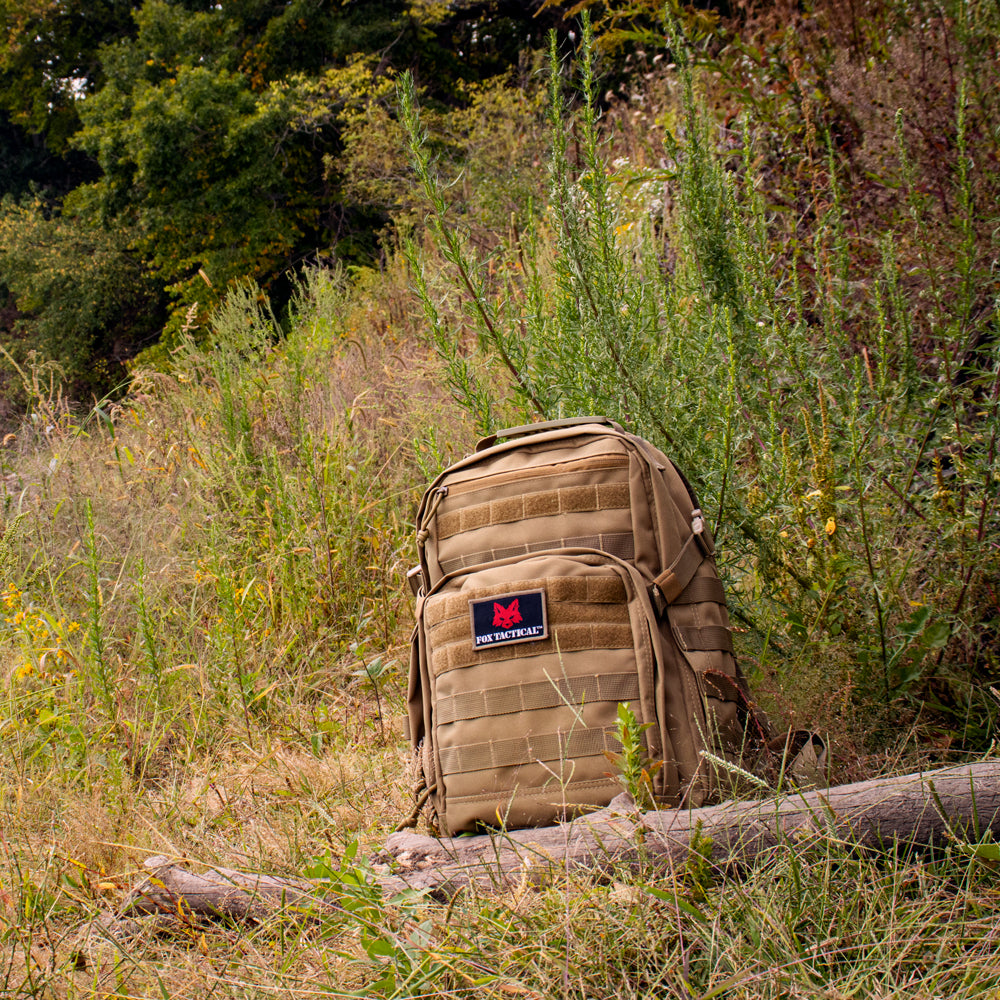 Liberty Tac Pack sitting in a field on top of a fallen tree.