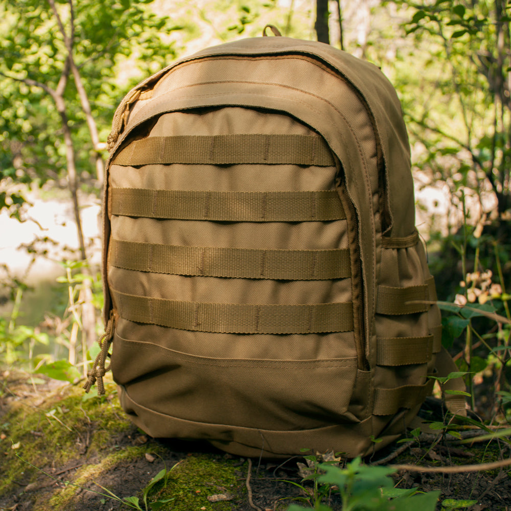 Level 1 Tac-Pack on mossy ground with bright foliage and a creek in the background.