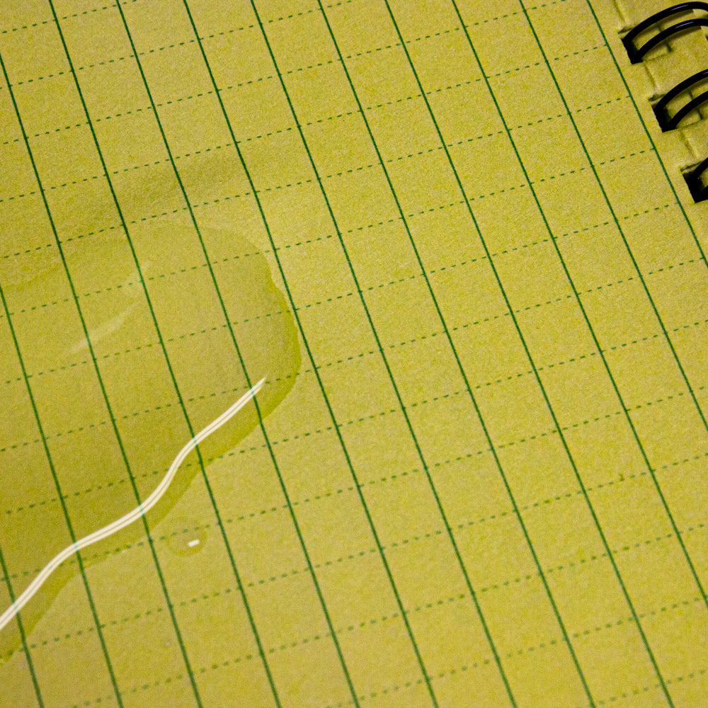 Closeup of water pooled on a page inside a Military Style Weatherproof Notebook.