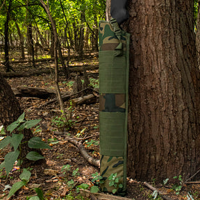 Tactical Shotgun Scabbard propped up against a tree in the woods.