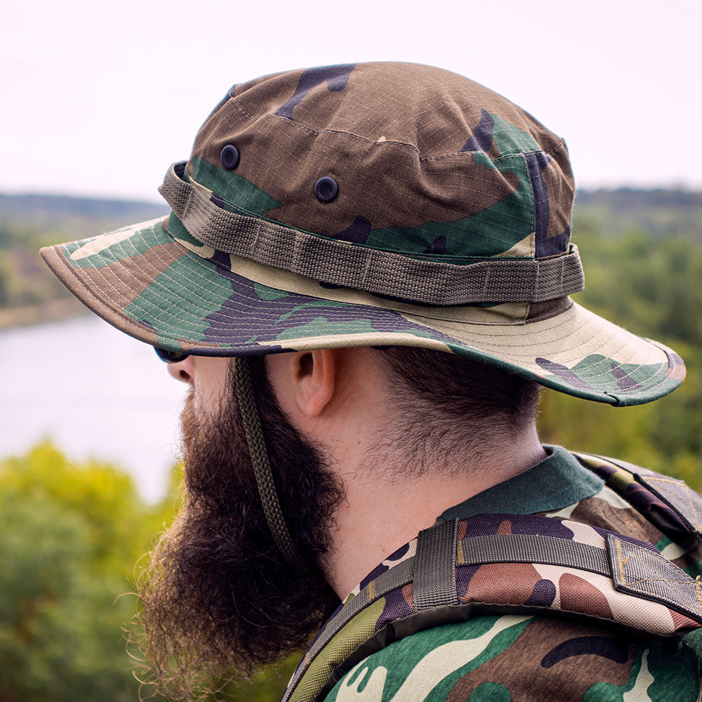 Man wearing a Boonie Hat, overlooking a river from a high vantage point.