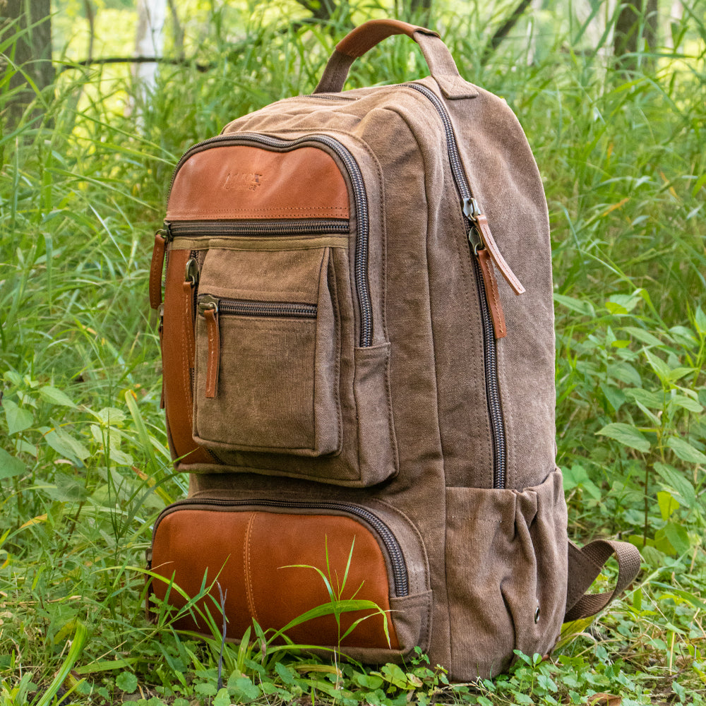 Retro Cantabrian Excursion Rucksack with leather in a grassy field.