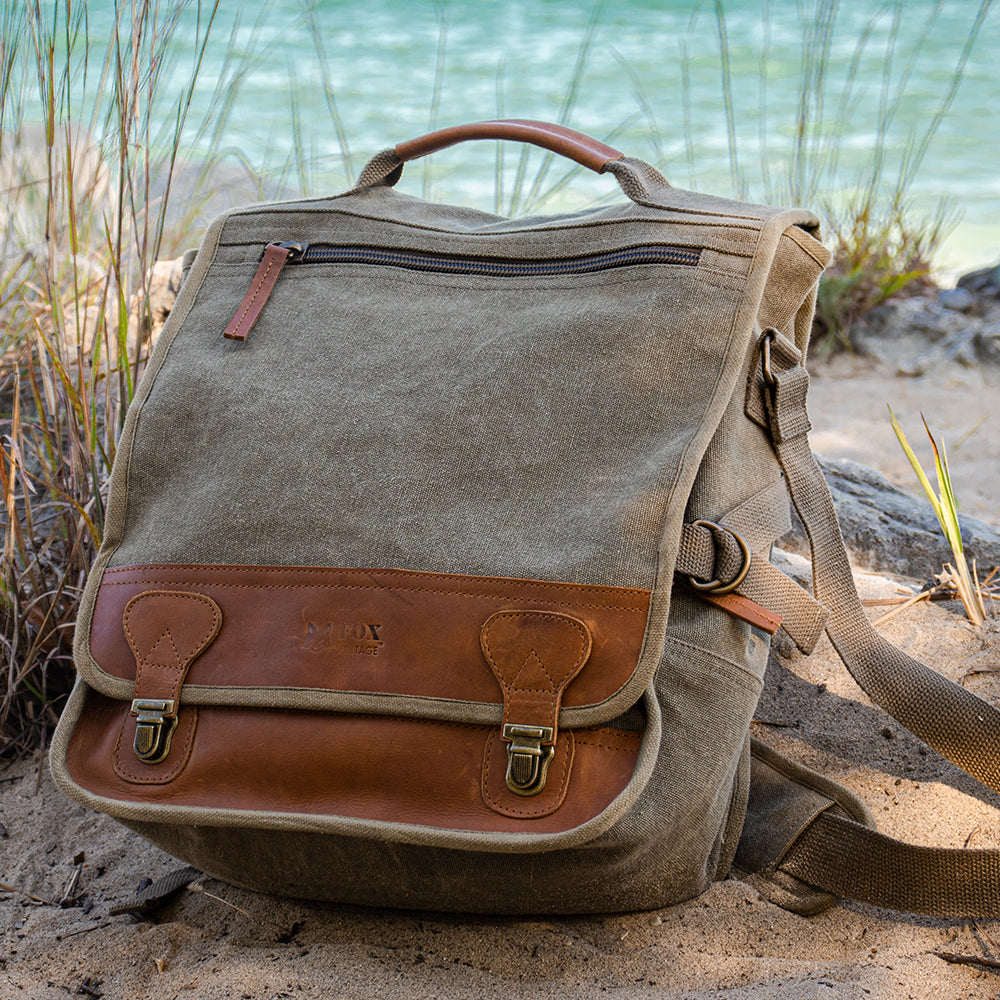 Classic Eurostyle Messenger Bag sitting on a sandbank in front of a bright, large body of water.