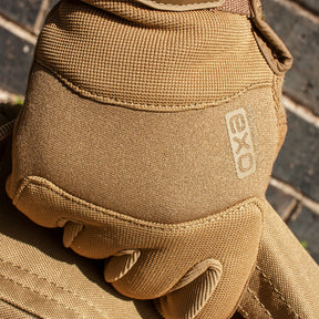 Close-up of person wearing Ironclad® EXO Tactical Pro Series Glove carrying a bag in front of a brick wall.