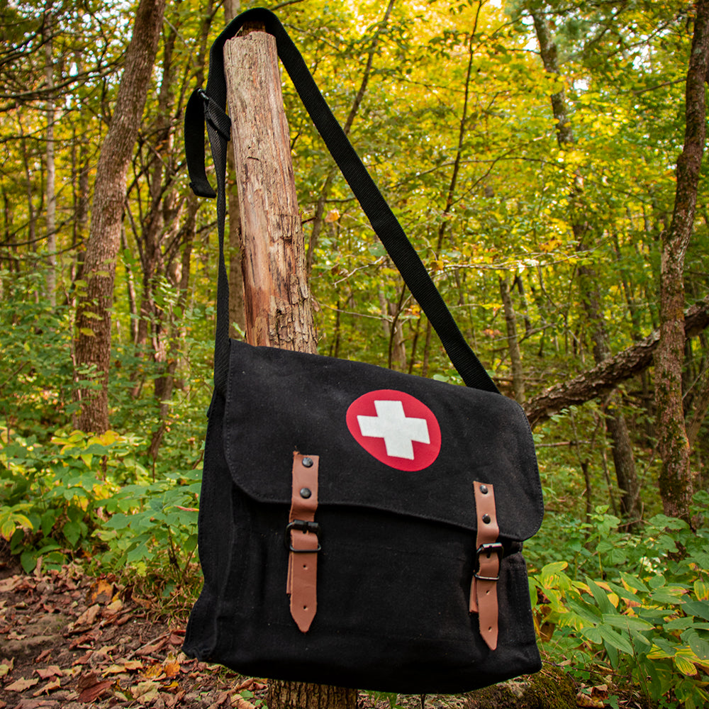 German Medic Bag hung on a small, cut tree in the woods.