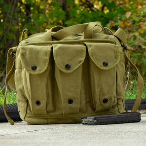 Mag/Shooter's Bag sitting on concrete, with a loose mag in front and a rifle behind it. 