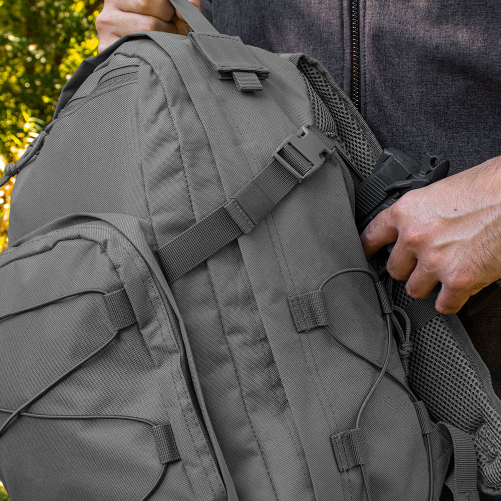 Man pulls pistol out of the concealed carry back pocket in the CCW Rogue Daypack.