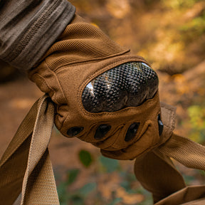 Close-up of Tactical Assault Glove carrying a tactical bag outside in the woods.
