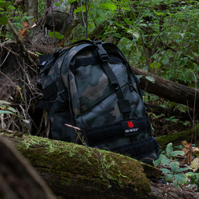 Large Transport Pack nestled inbetween mossy logs in a lush forest.