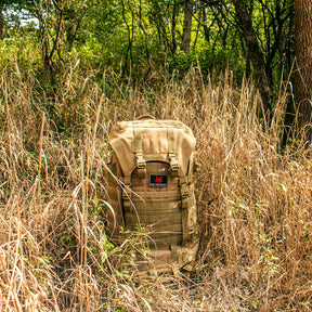 Advanced Mountaineering Pack partially hidden within tall prairie grass.